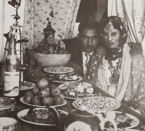 Fig. 31 Couple at henna table (note the decorated sugar cone behind the champagne bottle), Herat, 1963